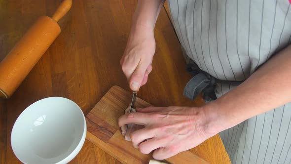 Chef Cuts a Piece of Bacon Into Cubes By Sharp Knife on the Wooden Board