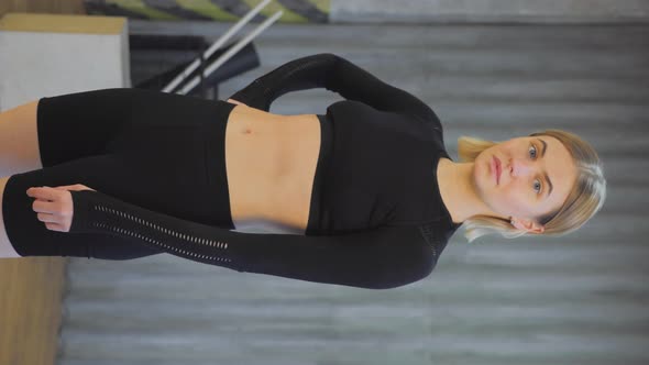 Vertical Video Portrait Of A Sporty Blonde Girl In A Sporty Black Top and Leggings Standing