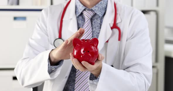 Doctor in White Coat Stroking Red Piggy Bank  Movie