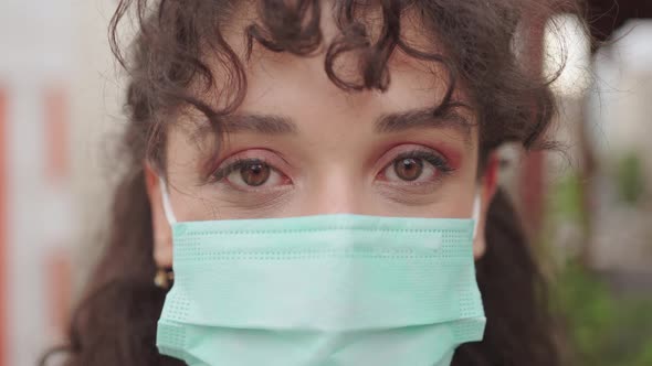 Young woman looking at camera with medical mask