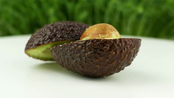 Avocado rotates on a green grass background. 4K video close-up of wholesome and healthy food