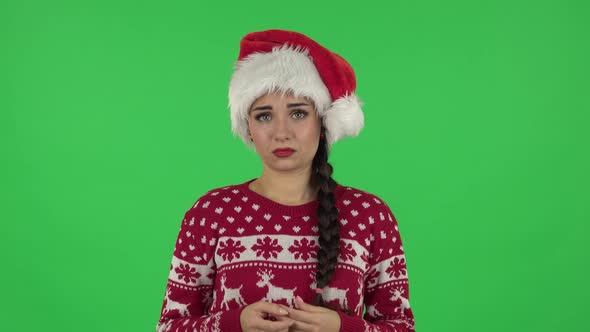 Portrait of Sweety Girl in Santa Claus Hat in Anticipation of Worries, Then Guilty Hides His Eyes