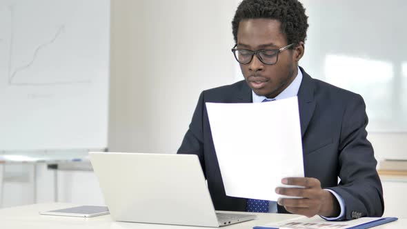 African Businessman Working on Documents in Office