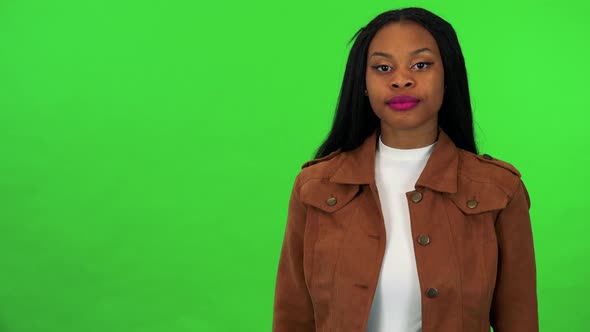 A Young Black Woman Points at the Camera and Nods with a Smile - Green Screen Studio