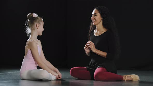 Hispanic Woman Teacher Coach Trainer Talking to Little Girl Student Ballerina Gymnast Teenager