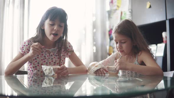 Children Draw on Paper. Two Little Girls Are Sitting at the Table at Home. Child with a Broken Arm