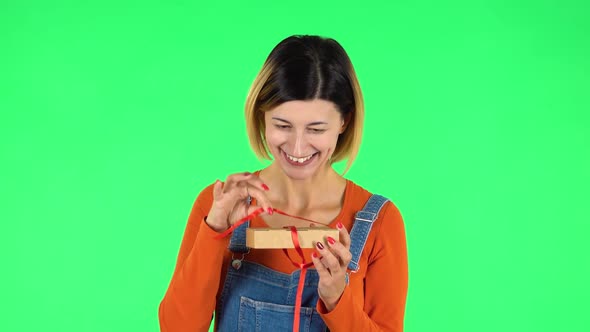 Girl Opens the Gift, Surprised and Rejoices. Green Screen