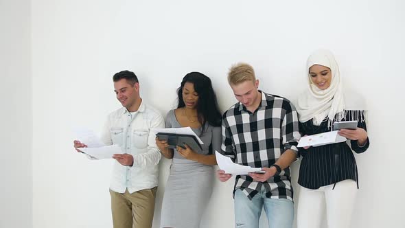 Young Concentrated Multiracial Corporate Coworkers which Standing Close to the Wall 