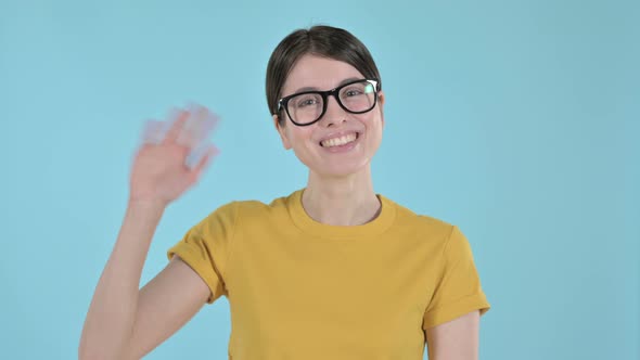 Young Woman Smiling and Waving Her Hand on Purple Background 