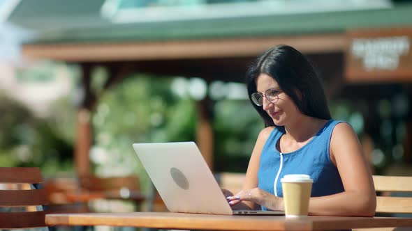 Busy Freelancer Brunette Girl Working on Laptop Pc at Outdoor Cafe Medium Shot