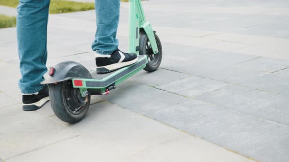 Closeup Shot of Male Legs Riding on Electric Scooter Outside at Urban City