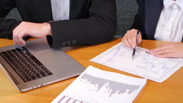 Two Young Men Discussing Charts and Applied To a Laptop