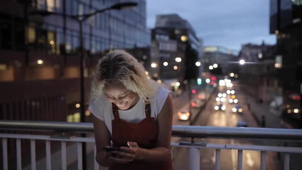 Pretty young woman typing message on smartphone, London, UK