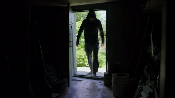 A Silhouette of Man That Comes in a Dark Room From the Street and Moves Quickly