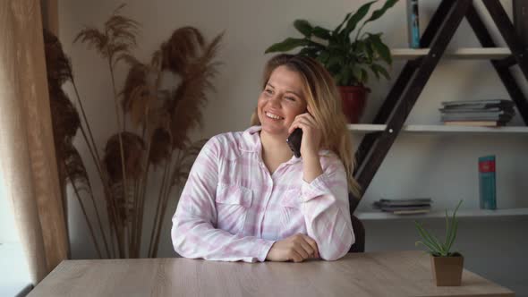Smiling Young Business Woman Talking on the Phone Sitting at Home Office Table Happy Female Customer