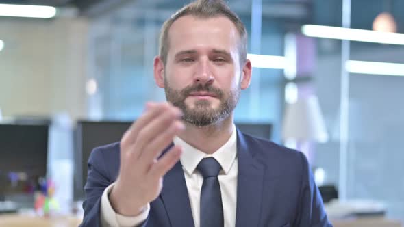 Portrait of Cheerful Businessman Pointing Finger and Inviting