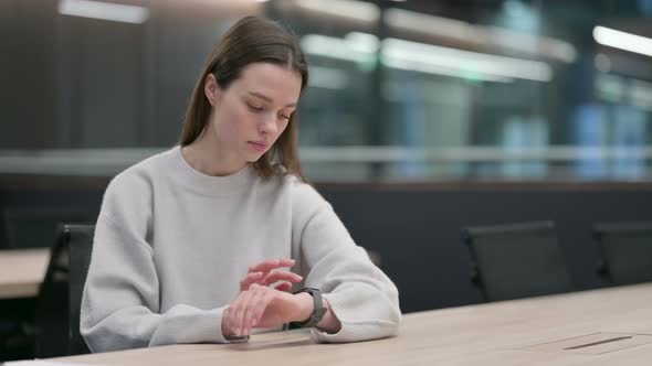 Woman using Smart Watch in Office