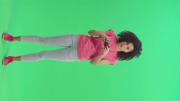 Portrait of Young Female African American Playing a Video Game Using a Wireless Controller