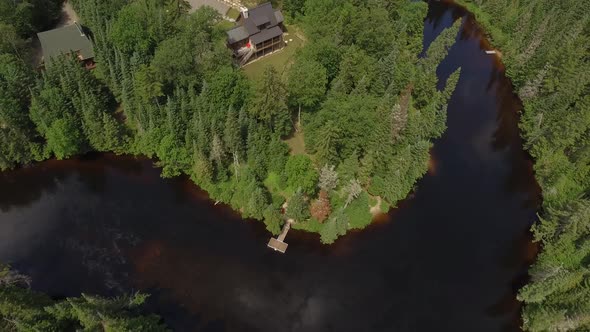 real estate aerial cottage fly backwards tilt up reveal property and mountains 4k