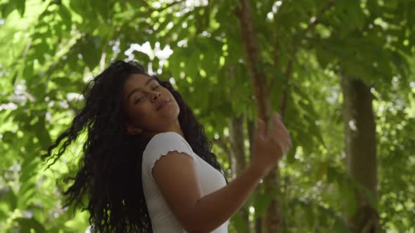 Pretty latina model playing in her hair low angle shot at a park