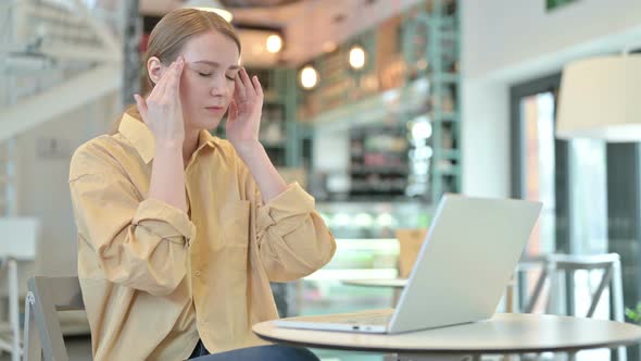 Young Woman with Headache Using Laptop in Cafe 