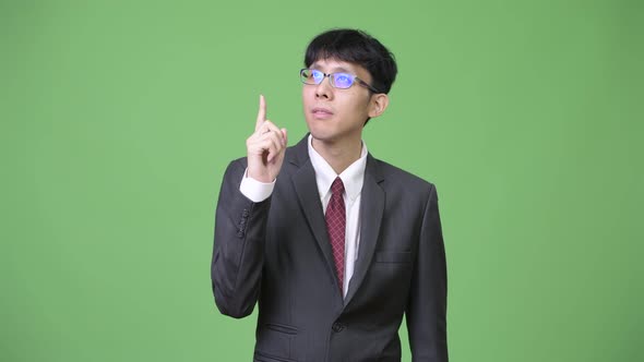 Young Asian Businessman Thinking While Pointing Finger Up