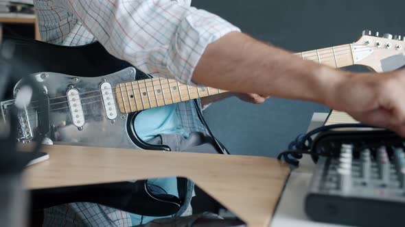 Closeup of Hand Using Sound Mixing Equipment Then Playing Electric Guitar While Musician Enjoying