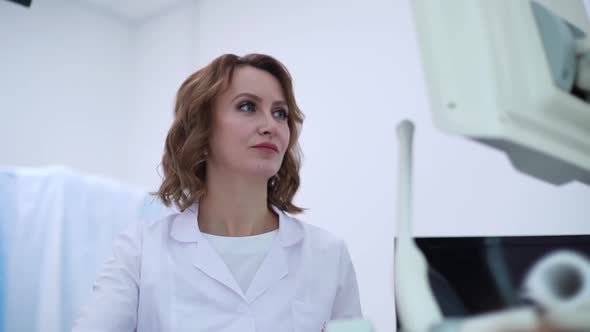 Close-up of Face of Obstetrician Gynecologist Performing Ultrasound of Belly of Pregnant Woman.