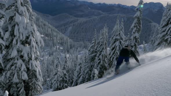 Snowboarder Carving Fresh Backcountry Powder Snow On Sunny Day