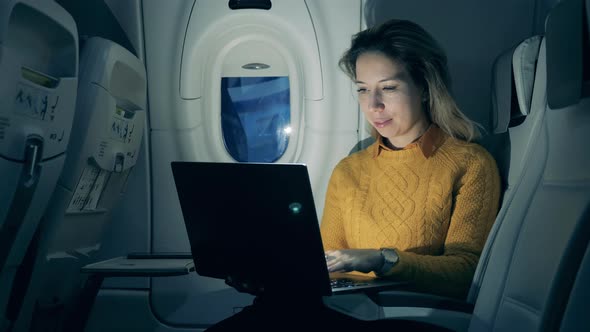 Night Flight and a Smiling Lady Working on a Laptop During It