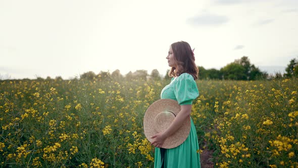 Portrait of Attractive Woman Posing in Blooming Canola Flowers Field