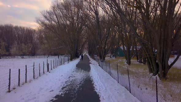 A fit person runs along a rural pathway in the cold winter morning