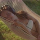 Girl Sleeps in Hammock Listening to Music Via Headphones - VideoHive Item for Sale