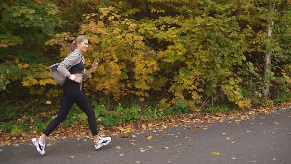 Happy Woman Enjoys Running in the Fresh Air, Sunny Warm Autumn Day