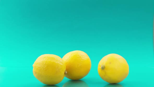 Falling Lemons One After One on Turquoise Background