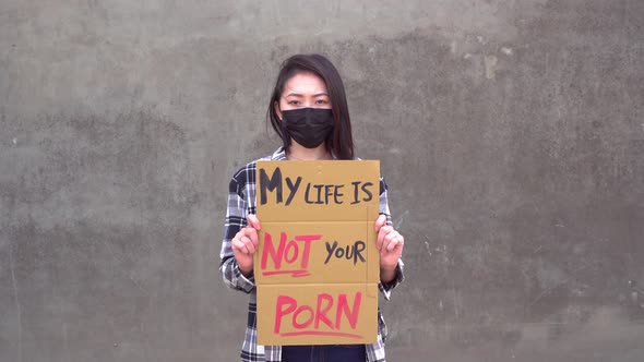 Asian woman with poster during protest against sexual harassment