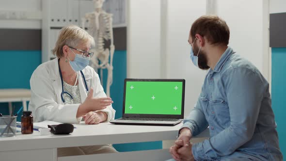 Doctor and Patient Looking at Laptop with Greenscreen