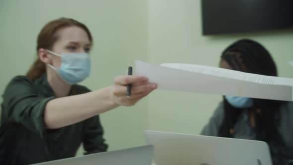 A Young Lady is Working and Passing the Papers Over