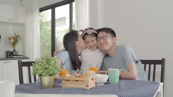 Parent and daughter eating Cereals with milk having breakfast morning in kitchen.