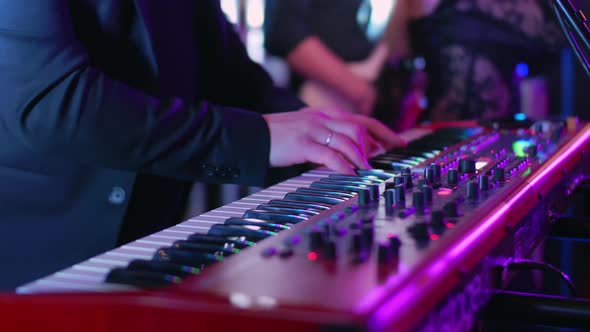 A Caucasian Man Plays Electric Piano at a Concert Party Music Party Neon Colors Playing Chords on