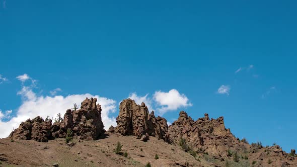 Time lapse of clouds moving past rocky formation