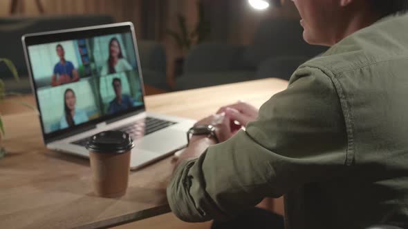 Asian Man Sitting In A Wheelchair While Video Call On Laptop Computer At Home, Night Time