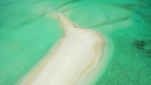 Wide angle fly over travel shot of a white sand paradise beach and blue water background in colourfu