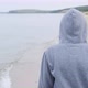 A Man in a Hoodie Walks Along the Seashore - VideoHive Item for Sale