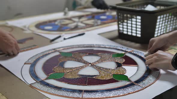 Two Artists Assemble a Composition From Stained Glass Details