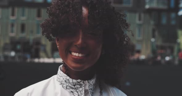 A young african woman with curly hairstyle smiling