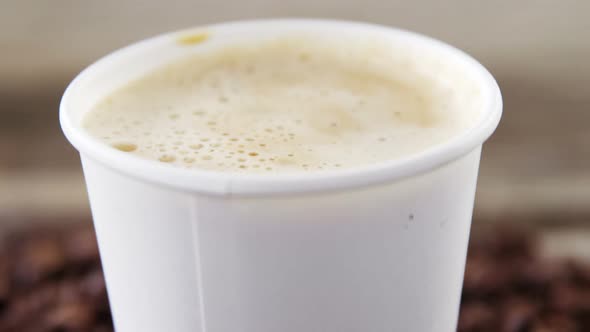 Coffee beans falling in disposable cup