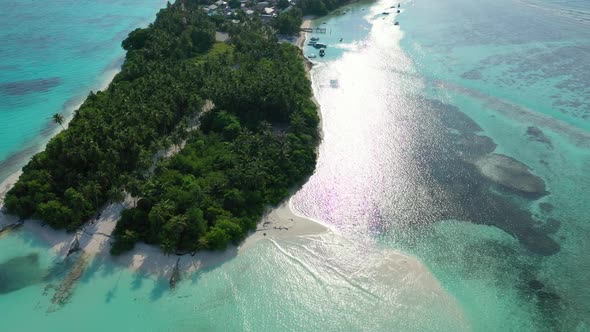 Aerial drone shot scenery of relaxing lagoon beach break by blue sea and white sandy background of a