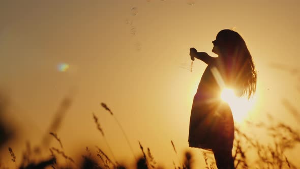 Carefree Kid Playing with Soap Bubbles at Sunset