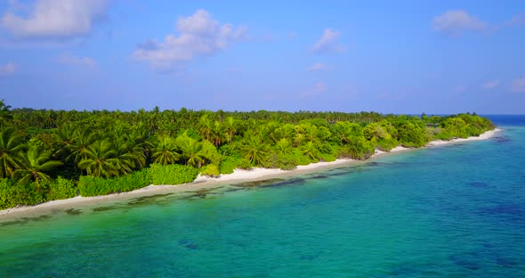 Daytime above travel shot of a white sand paradise beach and blue ocean background in hi res 4K